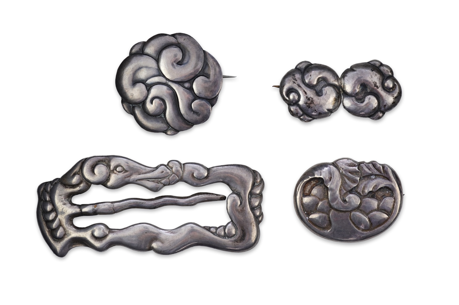 An Arts & Crafts silver slide and three silver brooches, probably Denmark, first half 20th century